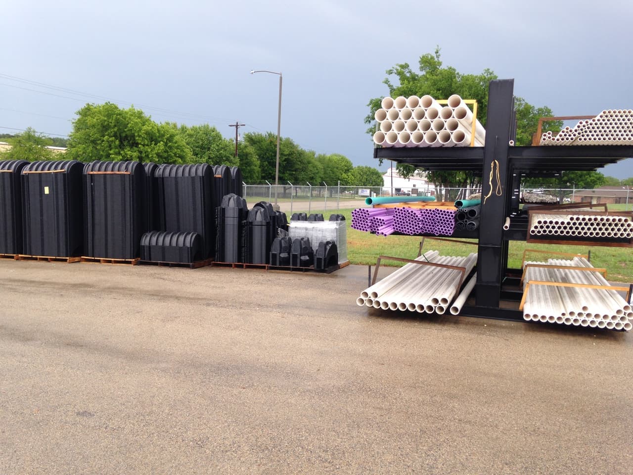 Outdoor pipe racks and stacked black plastic components at Smith Supply in Stephenville, TX
