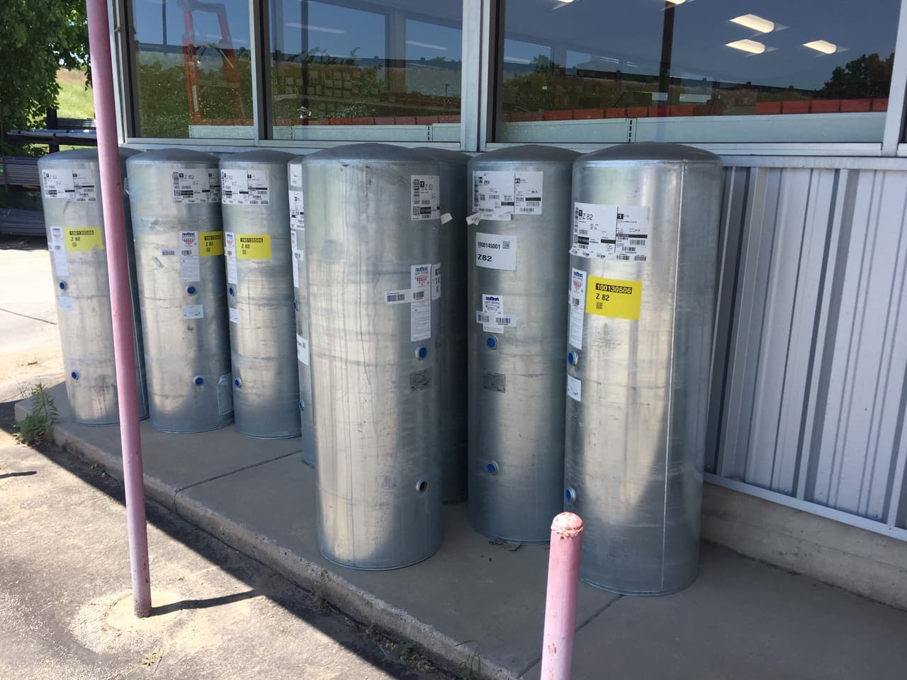 Galvanized steel tanks lined up outside the Smith Supply store windows in Stephenville, TX